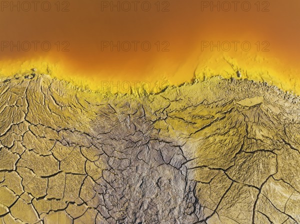 Cracked earth at the bank of the Rio Tinto (Red river) with its deep reddish hue due to oxidised iron minerals in its water, aerial view, drone shot, Huelva province, Andalusia, Spain, Europe