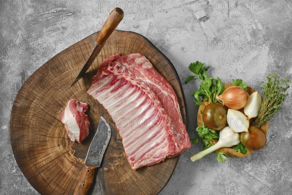 Overhead view of raw fresh lamb ribs on wooden slab