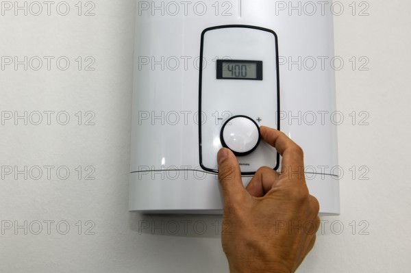 Instantaneous water heater for hot water shower washbasin bidet is set at temperature of 40 degrees Celsius with high consumption of energy electricity consumption electricity consumption, Germany, Europe