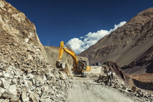 LADAKH, INDIA, SEPTEMBER 10, 2011: Excavator cleaning road after landslide in Himalayas. Ladakh, Jammu and Kashmir, India, Asia