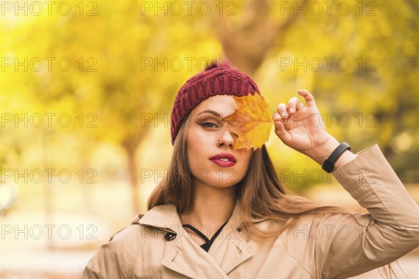 Outdoor atmospheric lifestyle portrait of a beautiful young woman in a forest in autumn