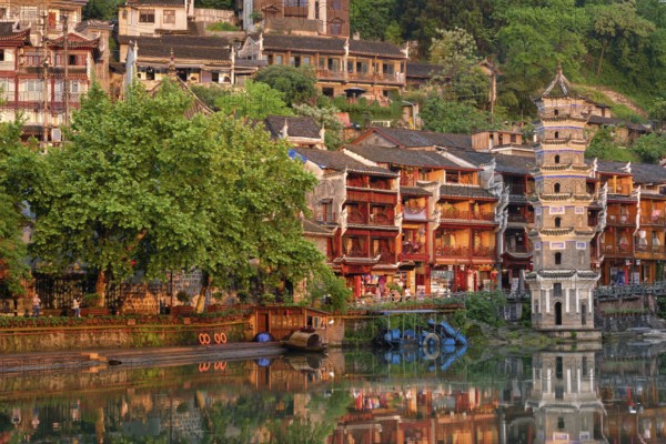 Chinese tourist attraction destination, Feng Huang Ancient Town (Phoenix Ancient Town) on Tuo Jiang River with Wanming Pagoda tower on sunset. Hunan Province, China, Asia