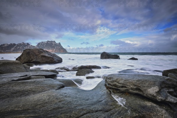 Rocks on beach of fjord of Norwegian sea in winter with snow. Utakliev beach, Lofoten islands, Norway, Europe