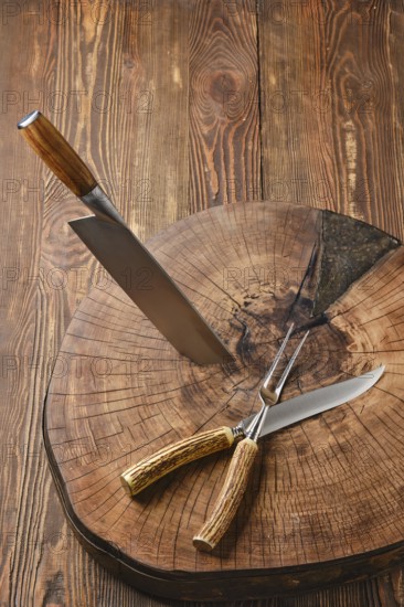 Overhead view of cleaver, fork and knife on wooden stump