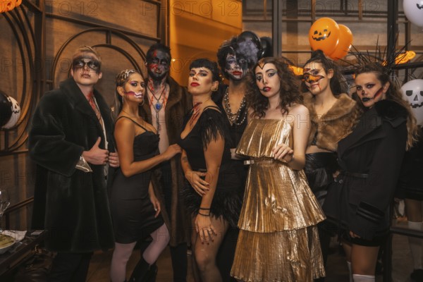 Halloween party with friends in a disco nightclub, portrait of a group of friends sitting on a sofa in makeup and costumes
