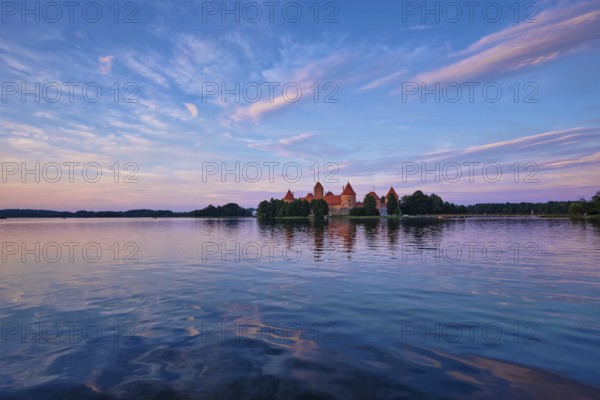 Trakai Island Castle in lake Galve, Lithuania on sunset with dramatic sky reflecting in water. Trakai Castle is one of major tourist attractions of Lituania