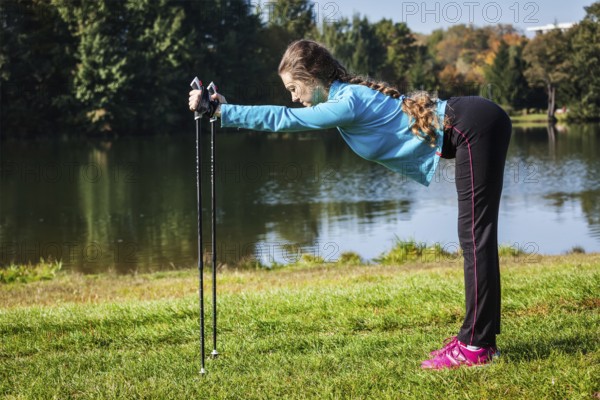 Nordic walking adventure and exercising concept, woman doing exercise with nordic walking poles in park