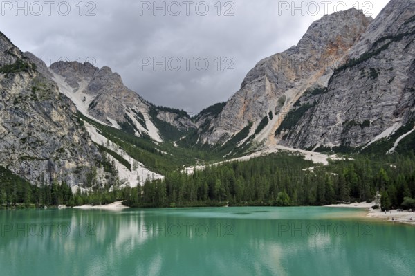 Turquoise water of the Lake Prags Lake, surrounded by pine forest and mountains in the Lake Prags Dolomites in South Tyrol, Italy, Europe