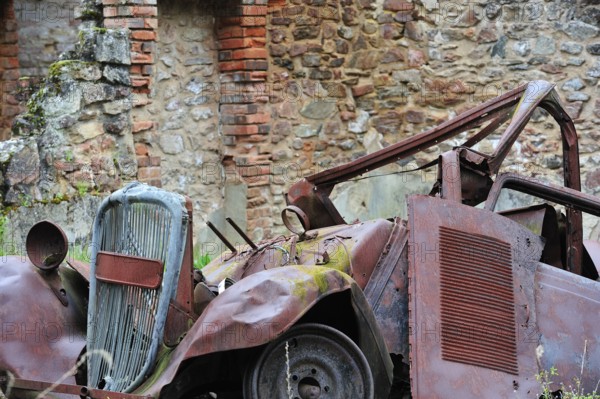 Burnt-out car in the garage. The burnt village of Oradour-sur-Glane was destroyed on 10 June 1944 when 642 of its inhabitants, including woman and children, were massacred by a German Waffen SS company, Limousin, France, Europe