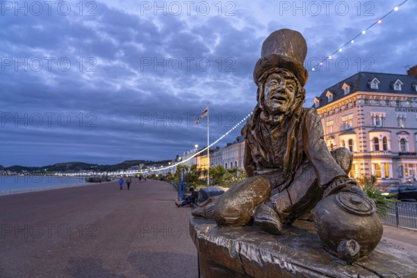 Sculpture of the Mad Hatter or The Mad Hatter from Alice in Wonderland on the promenade of the seaside resort of Llandudno at dusk, Wales, Great Britain