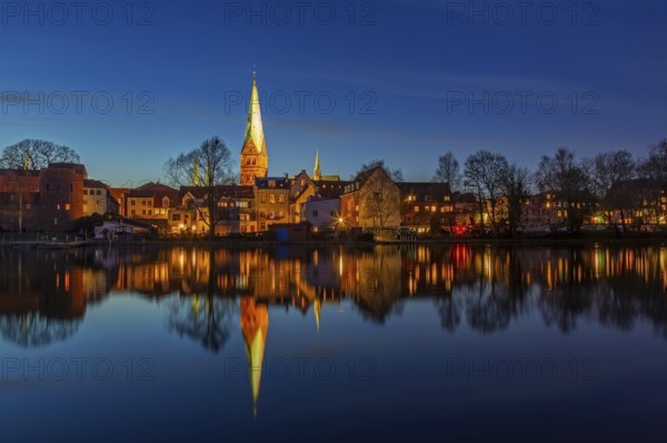 Houses and St. -Aegidien-Kirche, Aegidienkirche reflected in water at Krähenteich in the old city Lübeck at night, Schleswig-Holstein, Germany, Europe