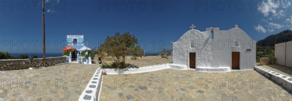 Café Skopi with small white church Parekkl?sia under a blue sky with a quiet Mediterranean atmosphere and a cobbled stone path, Mesochori, Karpathos, South Aegean, Greece, Europe
