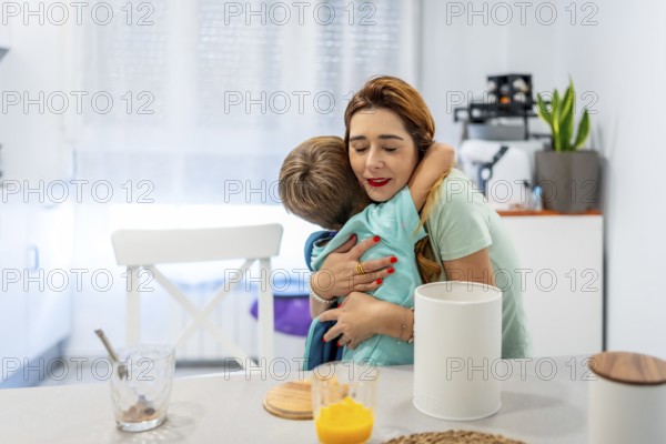 Happy moment of a caucasian school boy embracing her mother while eating breakfast at home