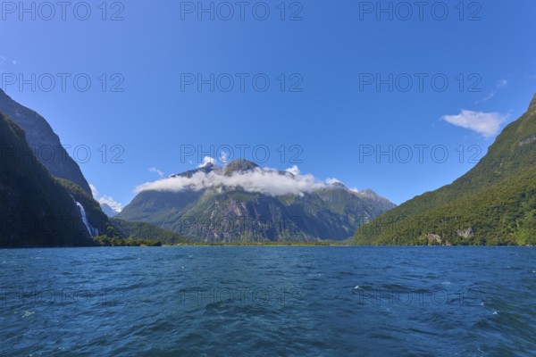 Majestic mountain landscape with clear fjord and light clouds under a sunny sky, summer, Milford Sound, Te Anau, Fiordland National Park, South Island, New Zealand, Oceania