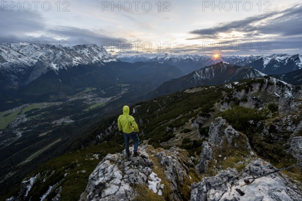 View Mountain panorama with Wetterstein mountains and Zugspitze, at sunset with sun star, mountaineer at the summit of the Kramerspitz, in autumn, Ammergau Alps, in autumn, Bavarian Prealps, Bavaria, Germany, Europe