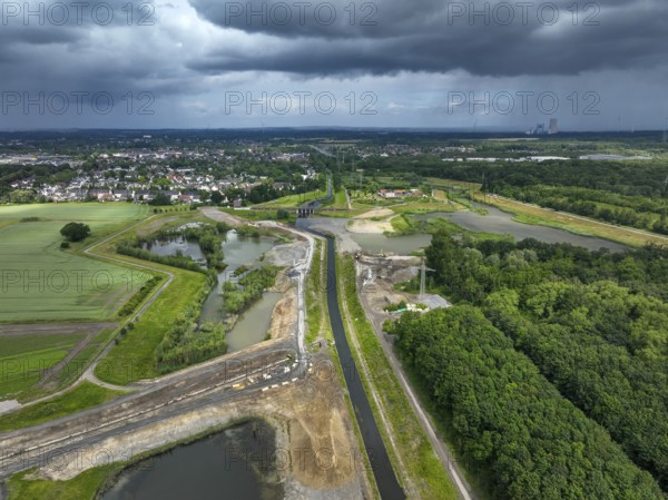 Dortmund / Castrop-Rauxel, North Rhine-Westphalia, Germany, river renaturalisation, renaturation of the Emscher, flood retention basin HRB Mengede. A new floodplain landscape is being created at the Emscher-Auen farm, expanding the area for flood protection during heavy rainfall and for biodiversity. The Emscher, which is currently straightened, will be given curves again and can meander through its new floodplain. Following the construction of a parallel sewer, the Emscher has been completely free of wastewater since 2022. The river was previously an open, above-ground mixed water channel with rainwater and wastewater. At the back right, the Uniper coal-fired power plant Datteln 4 power station, Europe