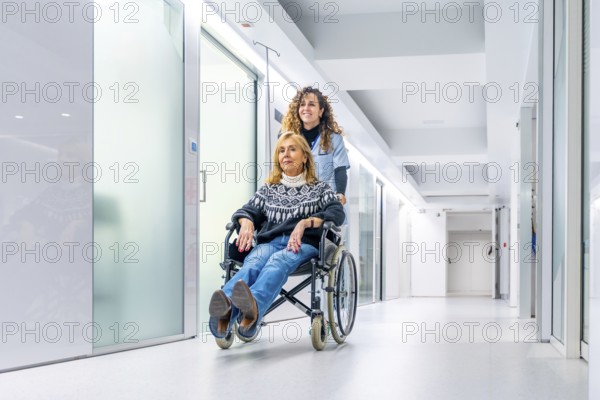 Injured mature woman in a wheelchair assisted by a nurse in the hospital