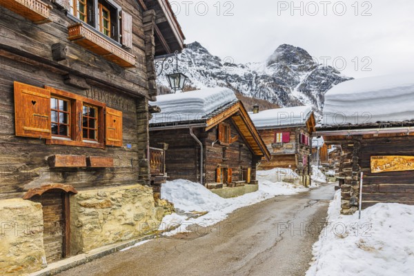 Street with historic old snow-covered wooden houses, mountain village of Zinal, Val d'Anniviers, Valais Alps, Canton Valais, Switzerland, Europe
