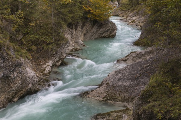 Rissbach creek flowing fast through the Riss valley. Autumn colors around