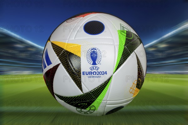 Symbolic image UEFA-EURO 2024: Close-up of the official match ball of the 2024 European Football Championship in Germany against the backdrop of a football arena (Composing)