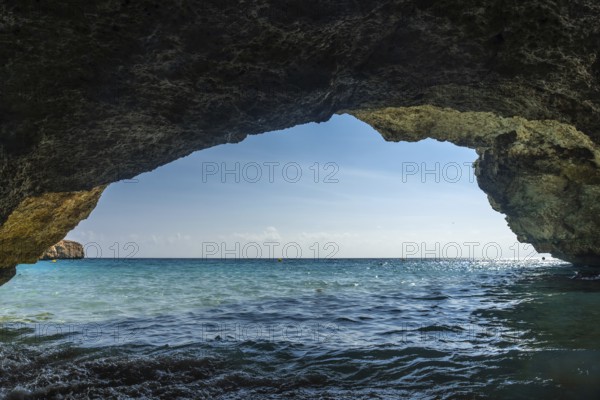 Breathtaking view of the turquoise waters of cala domingos beach in mallorca, spain, as seen from the inside of a cave on a sunny day