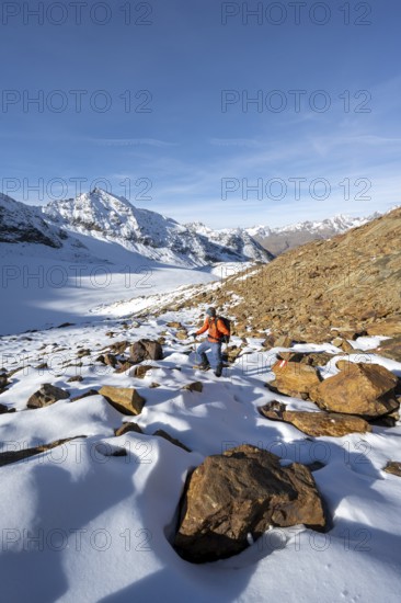 Mountaineer on a hiking trail with snow, descent from Ramoljoch at Spiegelferner, autumnal mountain landscape, mountain panorama with summit Wildspitze, Ötztal Alps, Tyrol, Austria, Europe