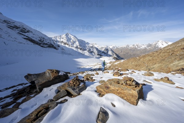 Mountaineer on a hiking trail with snow, descent from Ramoljoch near Spiegelferner, autumnal mountain landscape, Ötztal Alps, Tyrol, Austria, Europe