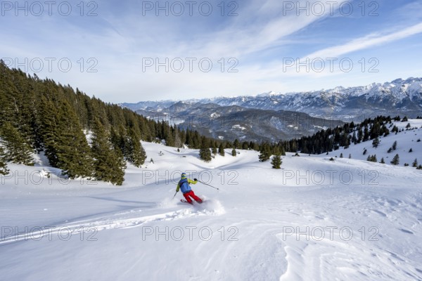 Skiers skiing down the Simetsberg, view of Walchensee and mountain panorama, Estergebirge, Bavarian Prealps, Bavaria Germany
