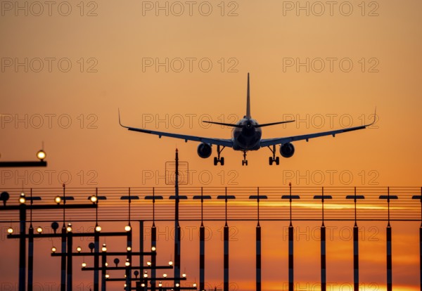 Aircraft approaching the main runway south, 05R/23L, runway lighting, approach aids, at Düsseldorf International Airport, sunset, North Rhine-Westphalia, Germany, Europe