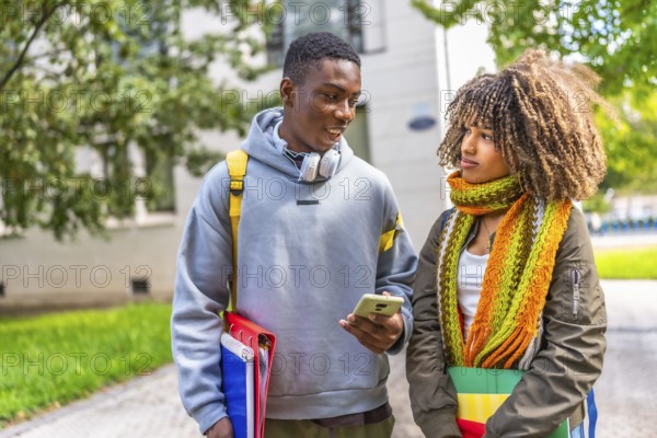 Multi-ethnic friends gathered together using a phone looking at social network content in the campus