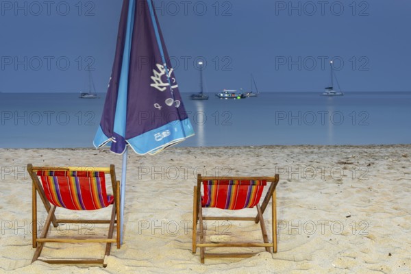 Abandoned deckchairs and parasol after sunset at Charlie Beach, Koh Mook Island, Andaman Sea, Thailand, Southeast Asia, Asia