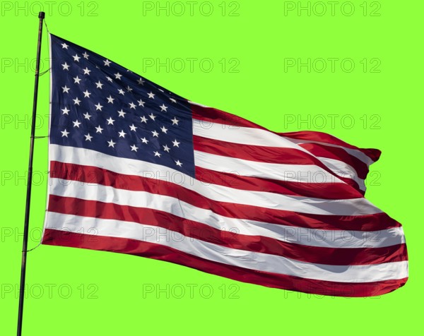 American flag waving in the wind on a flag pole over a green screen