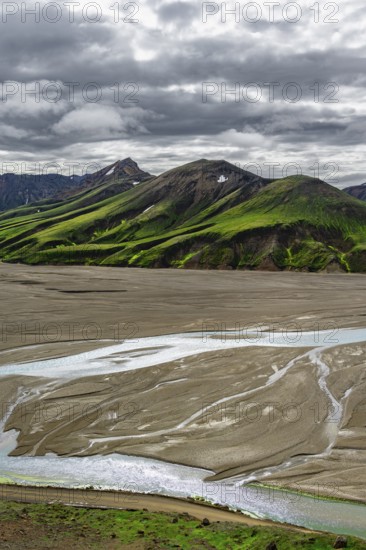 River in large riverbed, Moss-covered mountains, Rhyolite mountains, Volcanic landscape, Landmannalaugar, Fjallabak nature reserve, Icelandic highlands, Suðurland, Iceland, Europe