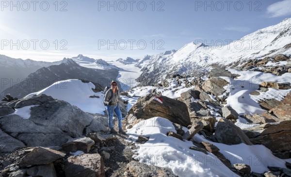 Mountaineer in front of mountain panorama and glacier, mountain hut Ramolhaus in autumn with snow, at sunset, view of Gurgler Ferner with summit Hochwilde and Falschungsspitze, Ötztal Alps, Tyrol, Austria, Europe