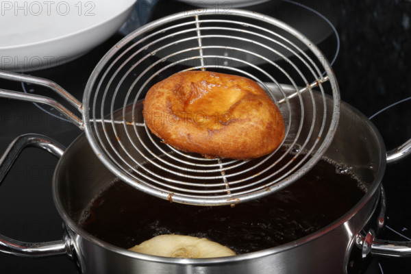 Swabian cuisine, preparation of harvest cakes, dessert, dessert, fat baked goods, doughnuts, fried food, lard noodles, grandmother's kitchen, regional, home cooking, typical Swabian, classic recipe, traditional cuisine, slotted spoon, food photography, studio, Germany, Europe