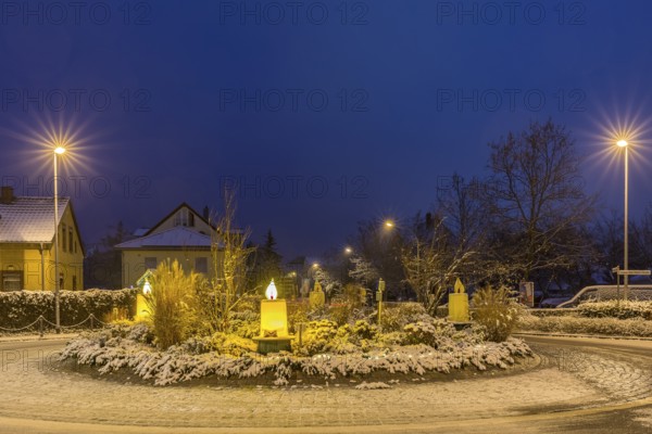 Advent candles at the roundabout, illuminated, snowy and at dusk, Coswig, Saxony, Germany, Europe