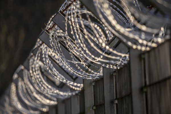 Symbolic image security, S-wire rolls, NATO wire, on a fence top, demarcation of a property, prevention of unauthorised access, strip steel wire with sharp blades