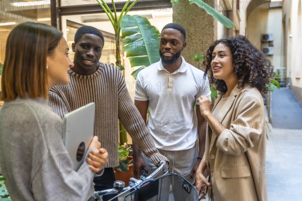 Diverse modern and young coworkers at the entrance of the office talking