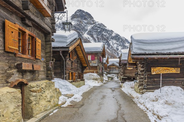 Street with historic old snow-covered wooden houses, mountain village of Zinal, Val d'Anniviers, Valais Alps, Canton Valais, Switzerland, Europe