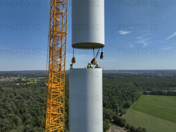 Dorsten, North Rhine-Westphalia, Germany, construction of a wind turbine, the first wind turbine of the Grosse Heide wind farm. A large mobile crane places the tower elements, the rings, on top of each other. This wind turbine will have a rated output of 5, 500 kW, Europe