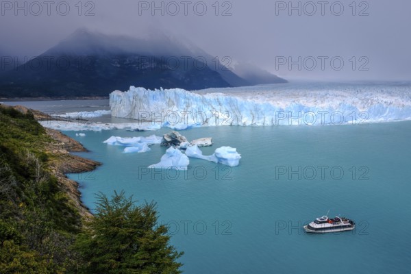 El Calafate, Patagonia, Argentina, Perito Moreno Glacier in Los Glaciares National Park. The Perito Moreno Glacier is part of the Patagonian ice field, the Campo Hielo Sur, the third largest freshwater reserve in the world. It is located in the province of Santa Cruz on Lago Argentino, the country's largest lake. The Perito Moreno Glacier is up to 30 kilometres long and 5 kilometres wide. Its edge is 70 metres high at its highest point. Small icebergs that have broken off from the glacier float in Lago Argentino. The glacier is one of the most beautiful sights in South America and is one of the most visited attractions in Argentina. Tourists can take an excursion boat to the glacier, South America