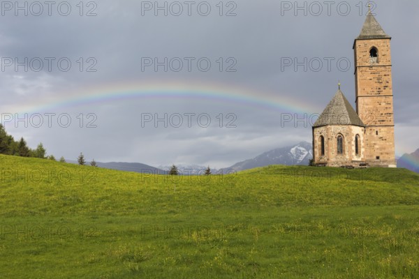 Church St. Kathrein, 39010 Hafling, Italy with a rainbow in the background. The church is from the 13 th century