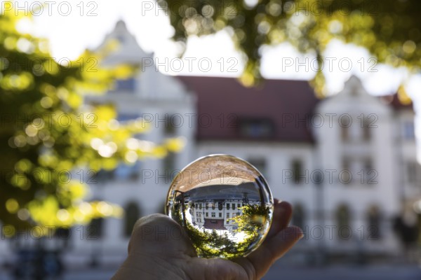 Hand with glass ball in which the Zentralgasthof refracts, Weinböhla, Saxony, Germany, Europe