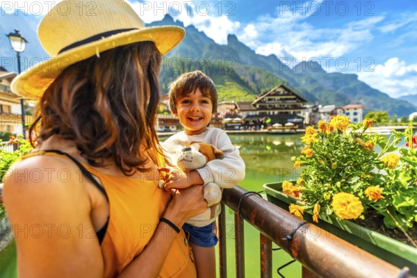 Tourists enjoying summer holidays in the picturesque village of alleghe, surrounded by the stunning dolomites and a peaceful lake