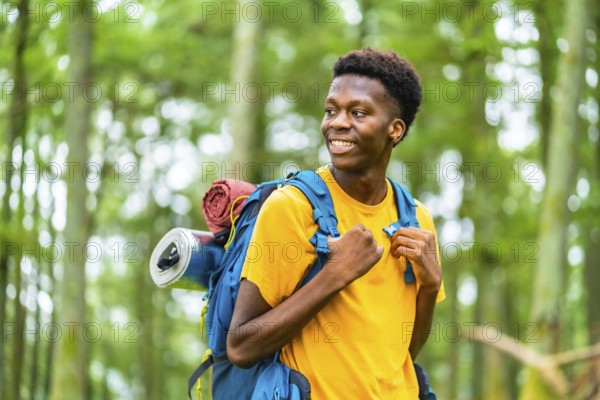 Distracted african young man enjoying nature hiking in the forest