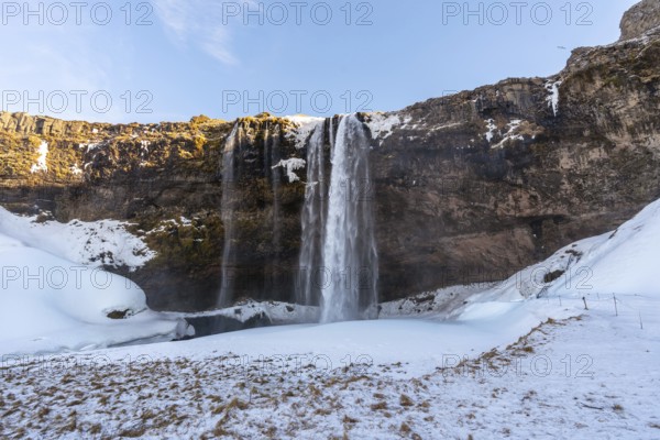 Beautiful Seljalandsfoss waterfall with snow in winter in Iceland