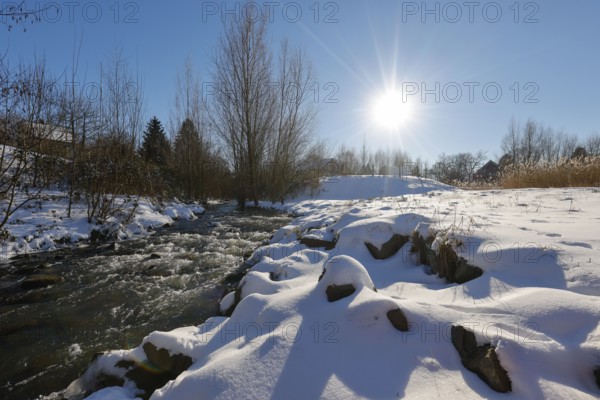 Dortmund, North Rhine-Westphalia, Germany - Sunny winter landscape in the Ruhr area, ice and snow on the renaturalised Emscher, the ecological conversion of the Emscher system consists of the construction of a central wastewater treatment system in the Ruhr area, the construction of underground sewers and the renaturalisation of the Emscher and its tributaries