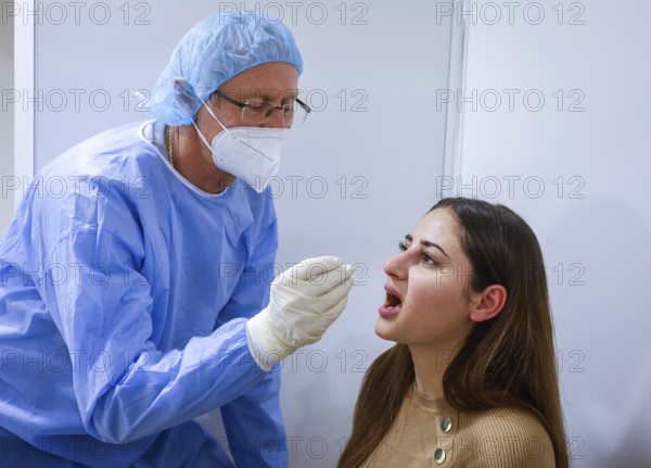 Essen, North Rhine-Westphalia, Germany - Corona test centre Grugahalle open for free citizen test, Covid rapid test, a doctor tests a young woman for the coronavirus using a throat swab, from 8 March, German citizens can be tested for corona once a week free of charge at the rapid test centre