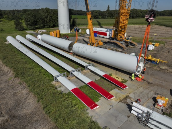 Dorsten, North Rhine-Westphalia, Germany, construction of a wind turbine, the first wind turbine of the Grosse Heide wind farm. The rotor blades are ready for assembly. A large mobile crane places the tower elements, the rings, on top of each other. This wind turbine will have a rated output of 5, 500 kW, Europe