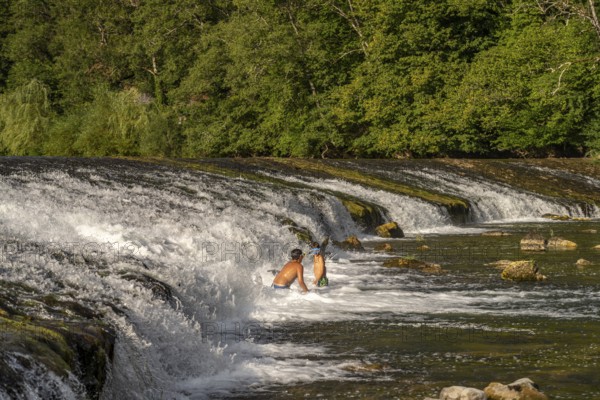 Children bathing at the weir in the Doubs river near Ocourt, Switzerland, Europe